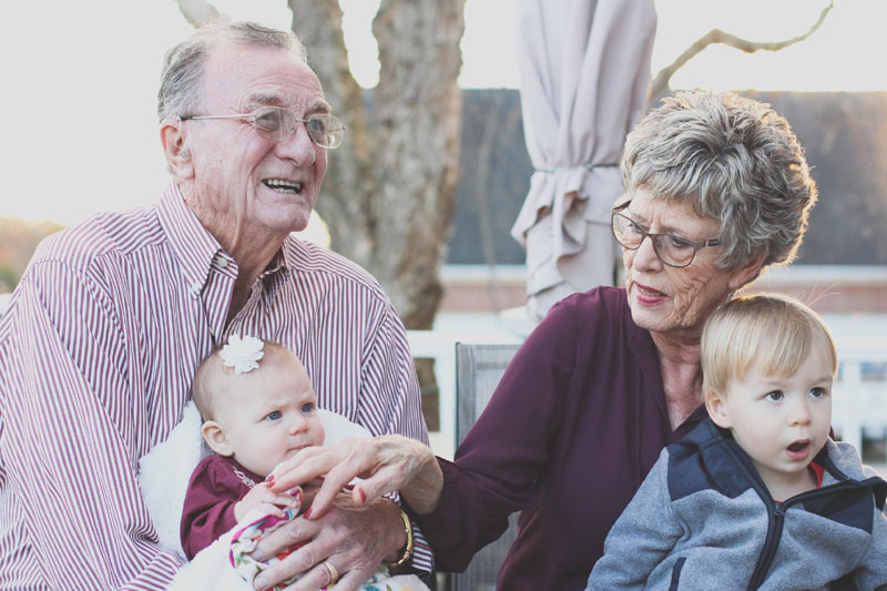 grandparents holding grandchildren on their laps